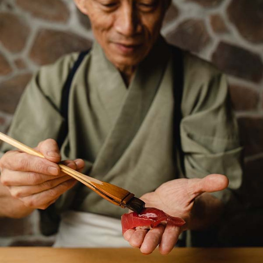  4th generation sushi chef Yukio Kimijima of Umi glazing food